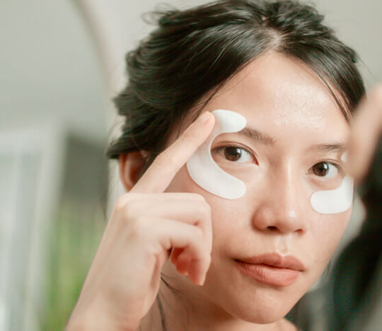Woman applying eye mask