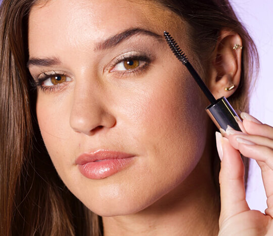 Woman brushing her eyebrows