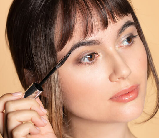 Woman brushing her eyebrows