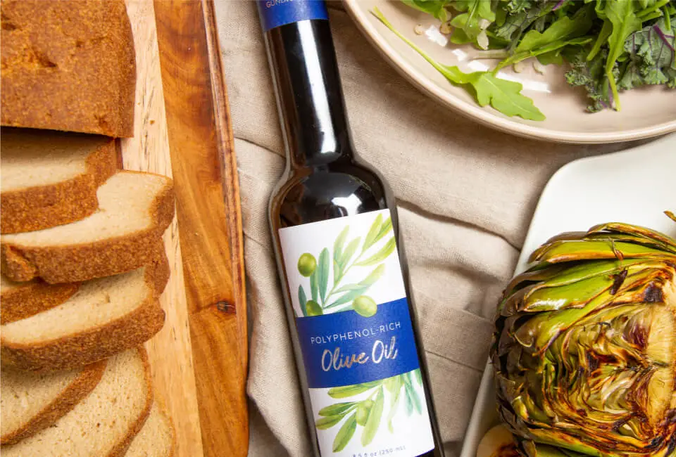 A bottle of Gundry MD Olive Oil next to a plate of bread