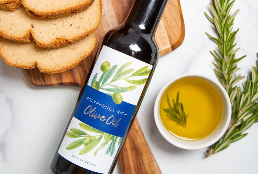A bottle of Gundry MD Olive Oil next to a plate of bread