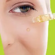 Photo of a woman that puts a drop of olive oil on her face